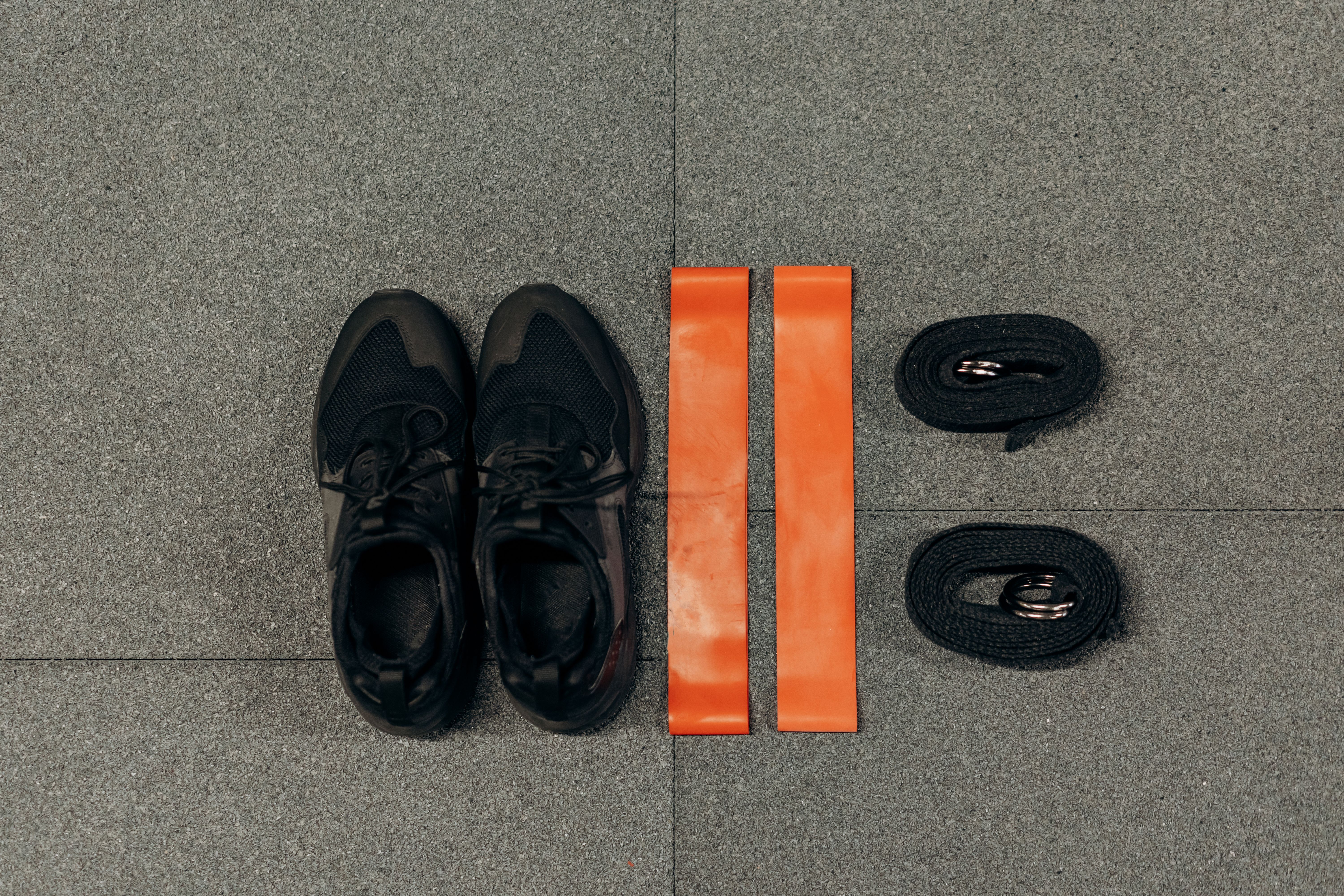 Flat lay of home fitness essentials: sneakers, resistance bands, and straps